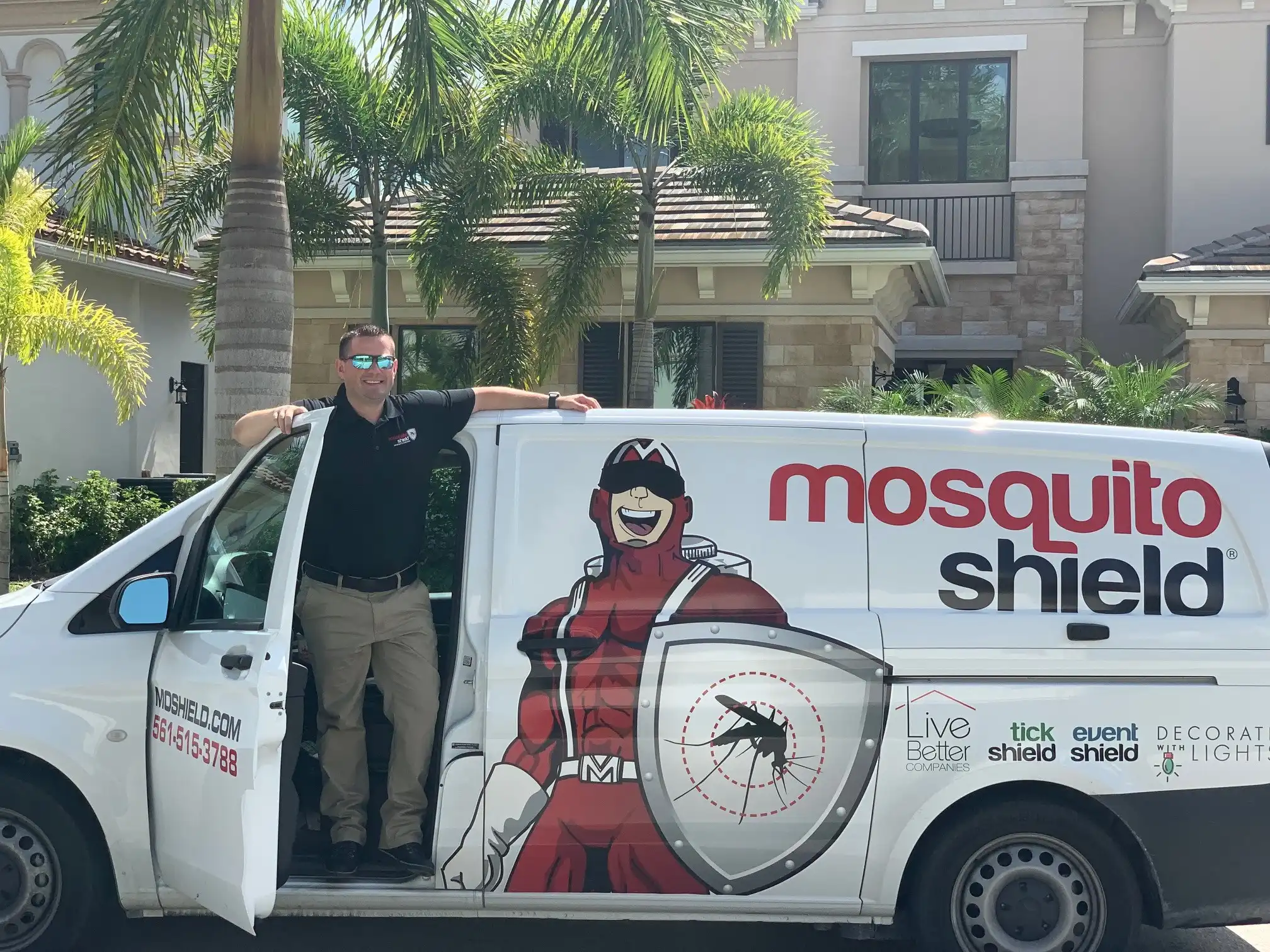 Eric Vincent, owner of Mosquito Shield Boca & Fort Lauderdale, with his service van in front of a South Florida luxury home